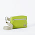 A vibrant lime green crossbody errand bag with zipper closure, an adjustable strap, and a silver-tone hardware, handcrafted from upcycled materials, bag named after Nadine.