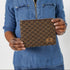 Hands holding a brown zip pouch with blue squares in the fabric named after Norma