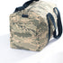Original pocket from a US Airforce unform on a camouflage duffel bag with blue cotton straps on a white background