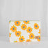 A large zip pouch with a white background and a vibrant floral pattern, featuring yellow flowers with blue centers. The pouch has a gold-tone zipper and a brand label in the bottom right corner.