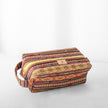 A toiletry kit with a multicolored geometric Santa Fe pattern and a tan Unshattered label 