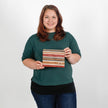 Woman in a green shirt holding a striped pouch named after Peanut
