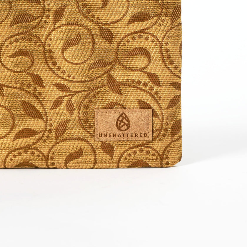 Patterned brown fabric with 'Unshattered' brand logo on a white background