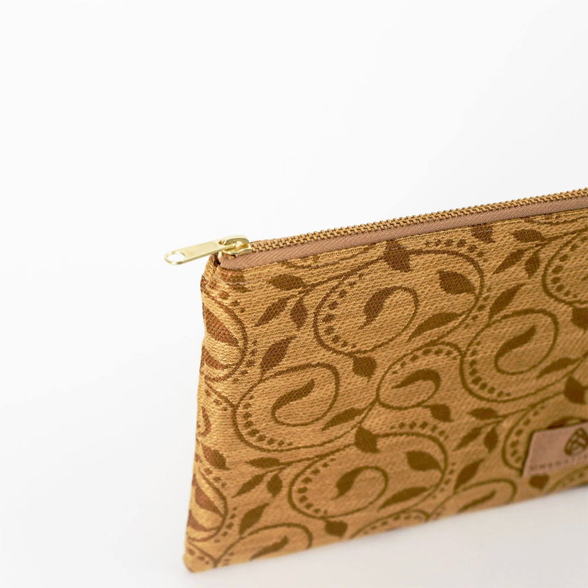 Close up of gold zipper on tan ivy pouch on a white background