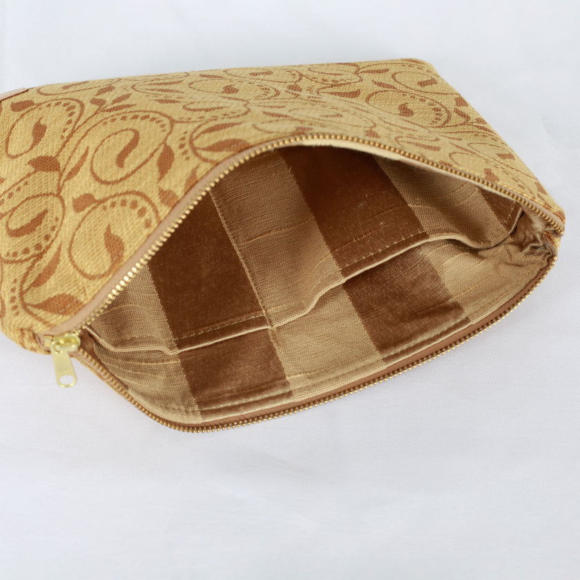 A gold striped interior on this yellow floral design large zip pouch on a white background 