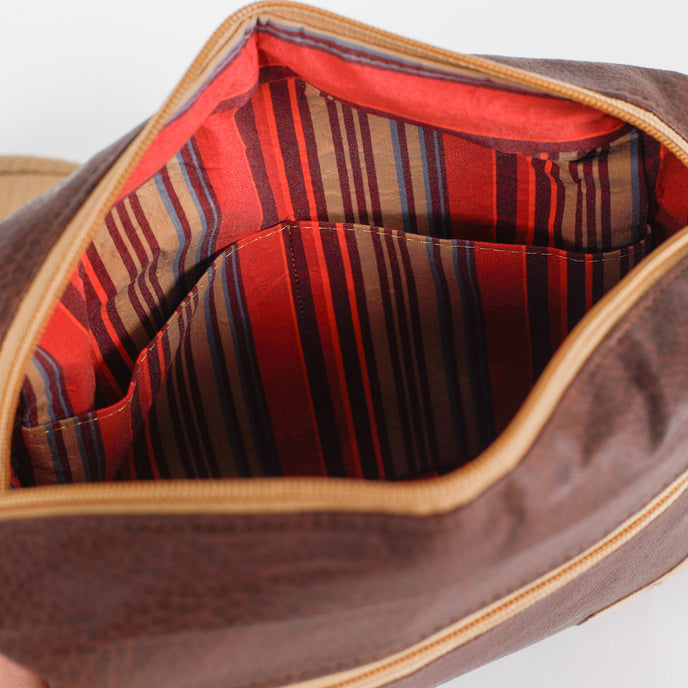 Close-up of colorful striped lining of a brown vegan leather bag named after Priscilla