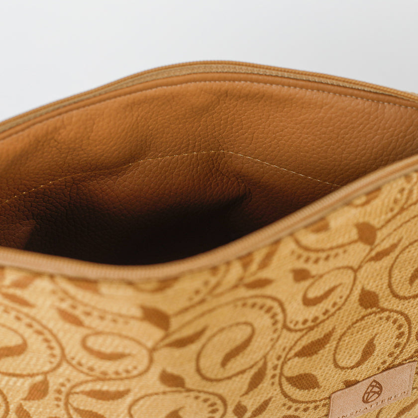 Close-up of a brown ivy fabric makeup kit with an brown luxury leather alternative material interior.