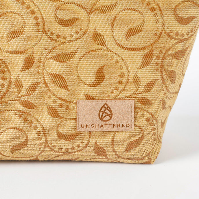 Textured makeup kit with brown ivy pattern and an 'Unshattered' brand logo on a white background