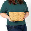 A woman holding a yellow design pattern makeup bag named after Priscilla 