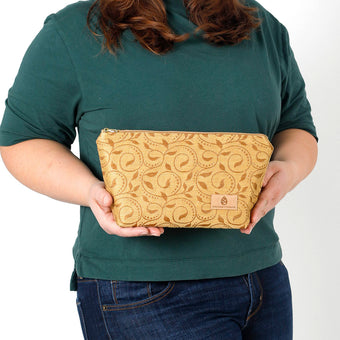 A woman holding a yellow design pattern makeup bag named after Priscilla 