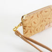 Beige patterned clip pouch with gold zipper and tan strap on a white background