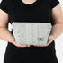 A woman holding a blue pattern design makeup kit named after Rebecca