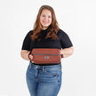 Woman holding a red leather toiletry kit against a white background