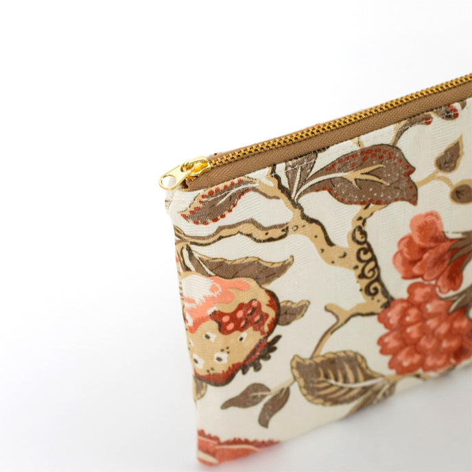 Floral-patterned pouch with a gold zipper on a white background named after Reisha