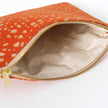 Orange pouch with khaki interior and gold zipper on a white background named after Rena 