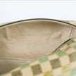 A close-up view of a cream-colored luxury leather alternative interior featuring elegant gold-toned stitching, showcased inside a checkered pattern upcycled toiletry bag.
