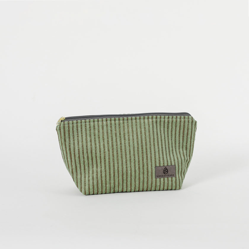 A green striped makeup kit with a zippered closure, made from upcycled materials.