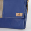 Blue leather bag with a 'Unshattered' brand label on a light gray background
