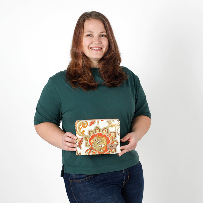 Woman holding a decorative zip pouch against a plain background named after Sara