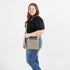 Woman wearing a crossbody bag on a white background