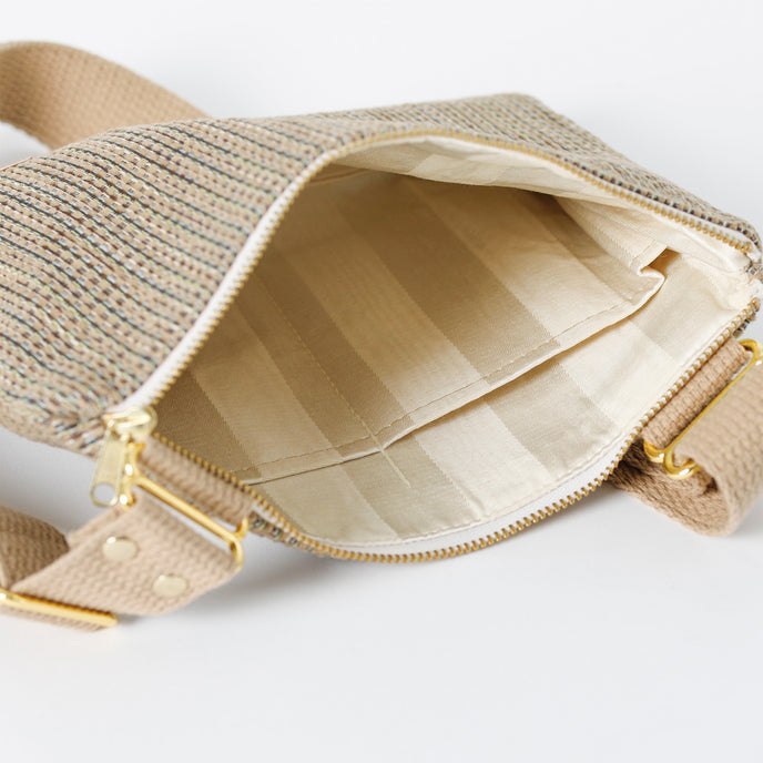 A striped interior fabric with a gold zipper and brown exterior named after Shakira.