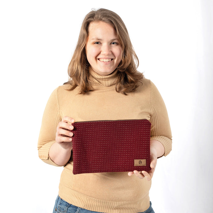 Woman holding a red large zip pouch  against a white background named after Shavonne