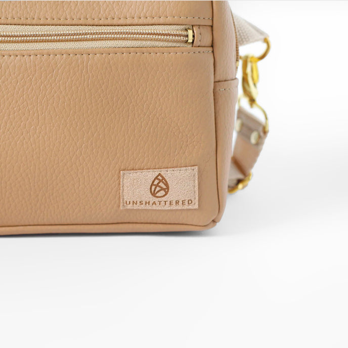 Beige errand with 'Unshattered' logo on a white background named after Shawna