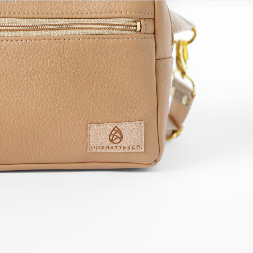 Beige errand with 'Unshattered' logo on a white background named after Shawna