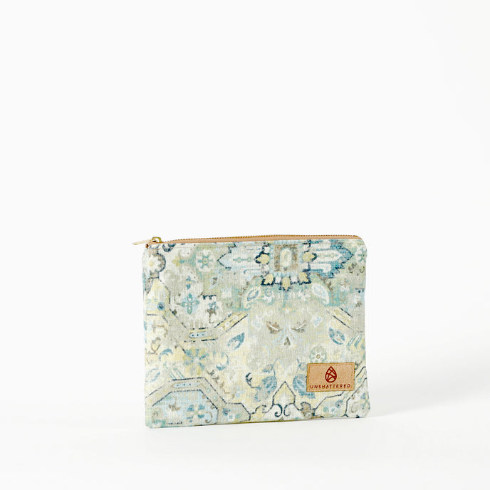 A seafoam-colored floral zip pouch with a secure zip closure and gold-tone hardware, handcrafted from upcycled materials bag named after Shelby 