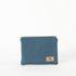 A small zip pouch with blue paisley fabric and gold-tone hardware, featuring a brand tag that reads Unshattered 