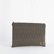 A light gray textured fabric zip pouch with brown polka-dot detailing and a brown leather brand tag on the bottom right corner.