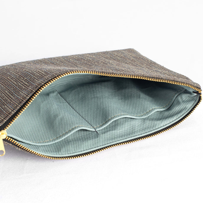 Gray large zippered pouch with light blue interior and gold zipper on a white background