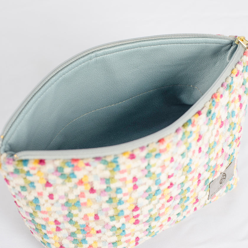 A light blue luxury leather alternative interior with a gold seam on a confetti puff plush makeup kit 