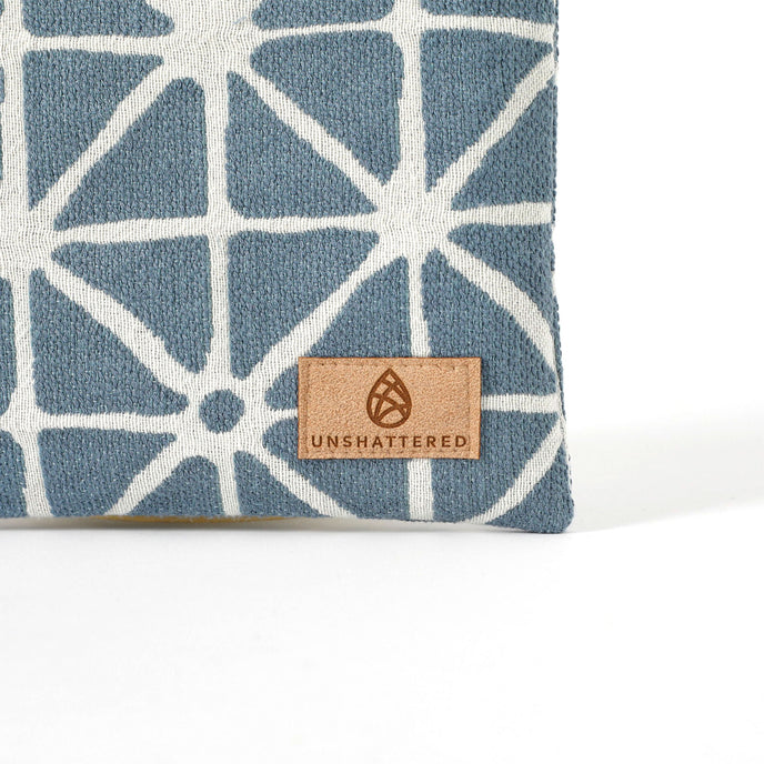 Suede Unshattered label on the Erica Zip Pouch handcrafted from upcycled blue geometric fabric