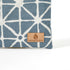 Suede Unshattered label on the Erica Zip Pouch handcrafted from upcycled blue geometric fabric