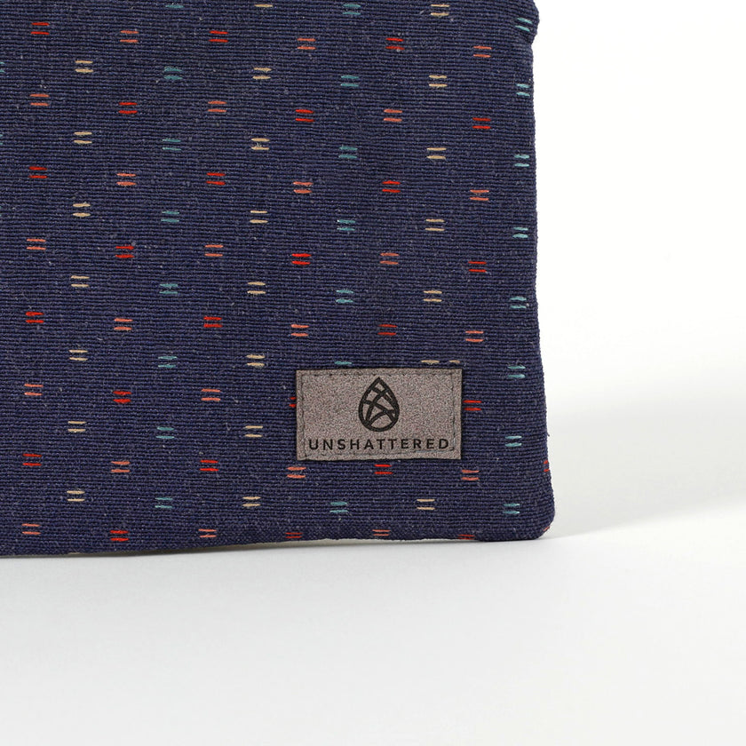 Gray suede Unshattered label on an upcycled blue fabric zip pouch named Nancy