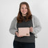 A woman holding a pink and yellow zip pouch named after Susan 