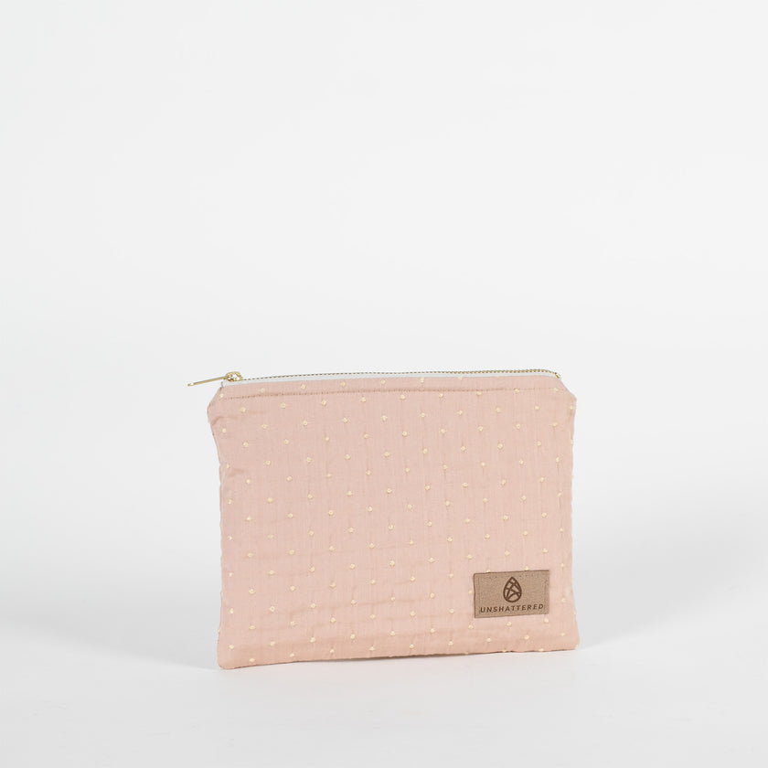 A pink and yellow zip pouch named after Susan featuring a tan Unshattered label 