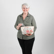 Woman holding a floral-patterned makeup bag  against a plain background named after Tamir 
