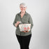 Woman holding a floral-patterned makeup bag  against a plain background named after Tamir 