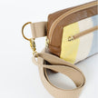 A tan strap with gold hardware on a wool yellow, white and blue errand bag with brown luxury leather alternative accents