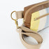 A tan strap with gold hardware on a wool yellow, white and blue errand bag with brown luxury leather alternative accents