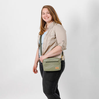 Woman holding olive green vegan leather crossbody bag named after Tasha