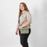 Woman holding olive green vegan leather crossbody bag named after Tasha