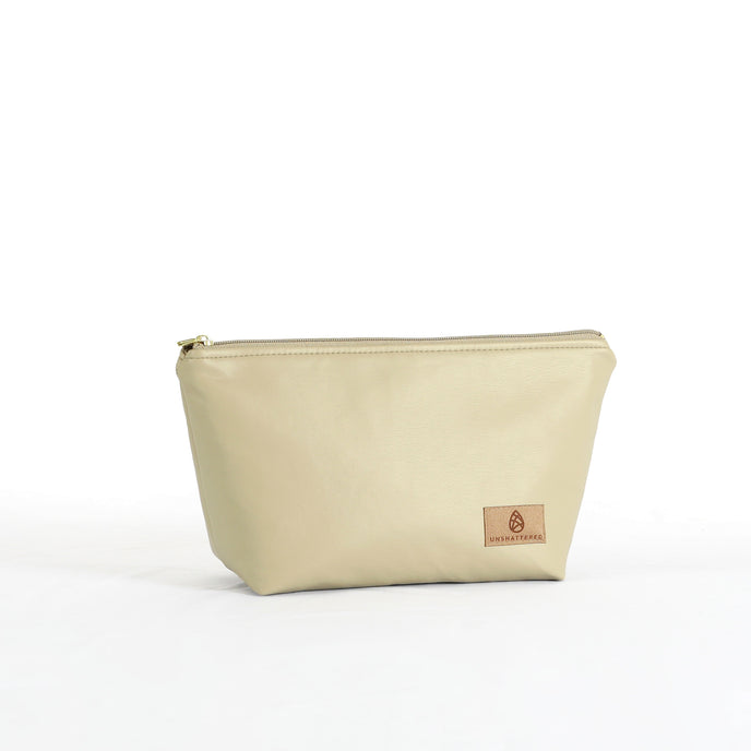 A taupe makeup kit with a zip closure, made from industrial luxury leather alternative, displayed against a white background.