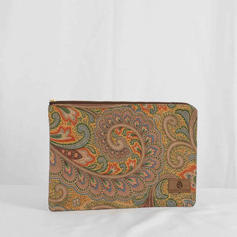 A large zip pouch with a paisley pattern in muted colors, featuring a brown zip closure and a small brown brand tag attached to the zipper.
