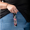 A black floral pattern loop keychain with a gray label and black hardware  