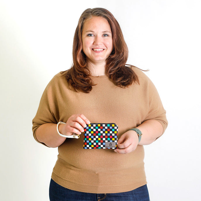 Woman holding a colorful patterned pouch against a white background