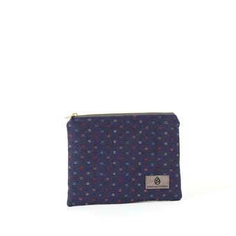 An upcycled blue fabric zip pouch named Nancy with a line rainbow pattern and gold-tone hardware on a white background