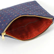 Upcycled red fabric interior on a dark blue zip pouch named Nancy on a white background